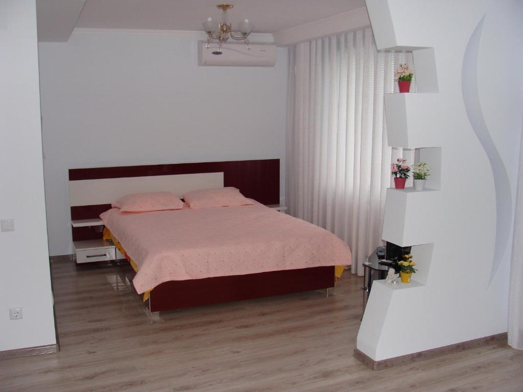 1 dormitorio con cama con sábanas rosas y almohadas rosas en Hotel Lidia, en Chişinău