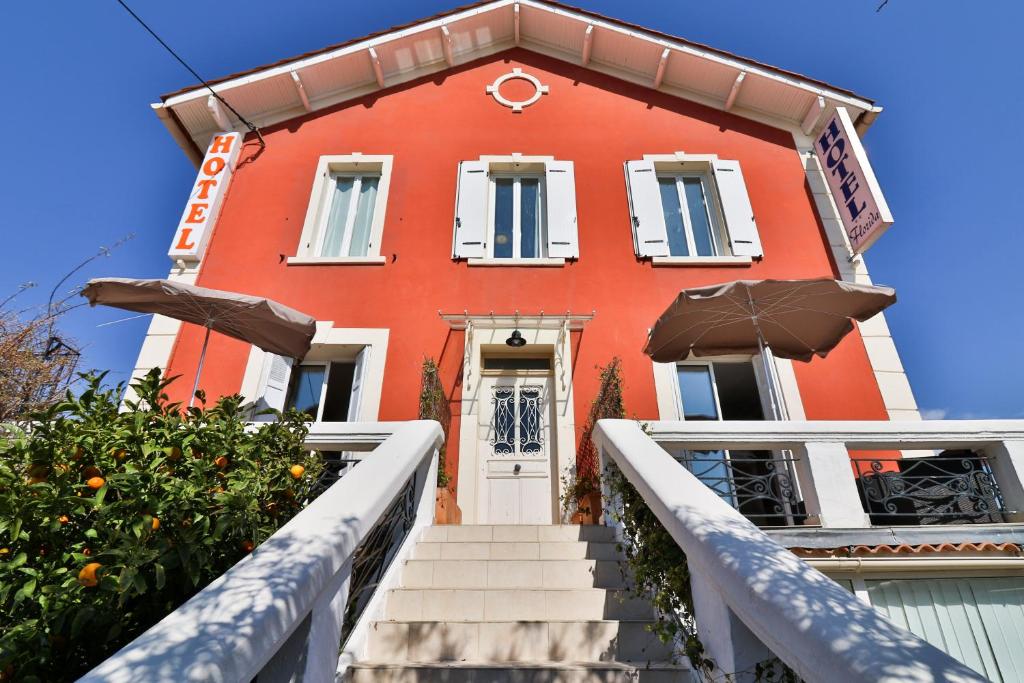 un edificio rojo con escaleras que conducen a la puerta principal en Hotel La Villa Florida, en Bandol