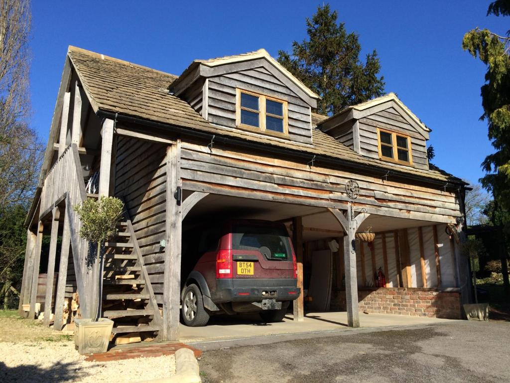 a car is parked inside of a garage at Greencourt Loft - The Cotswold Way, Stroud in Stonehouse