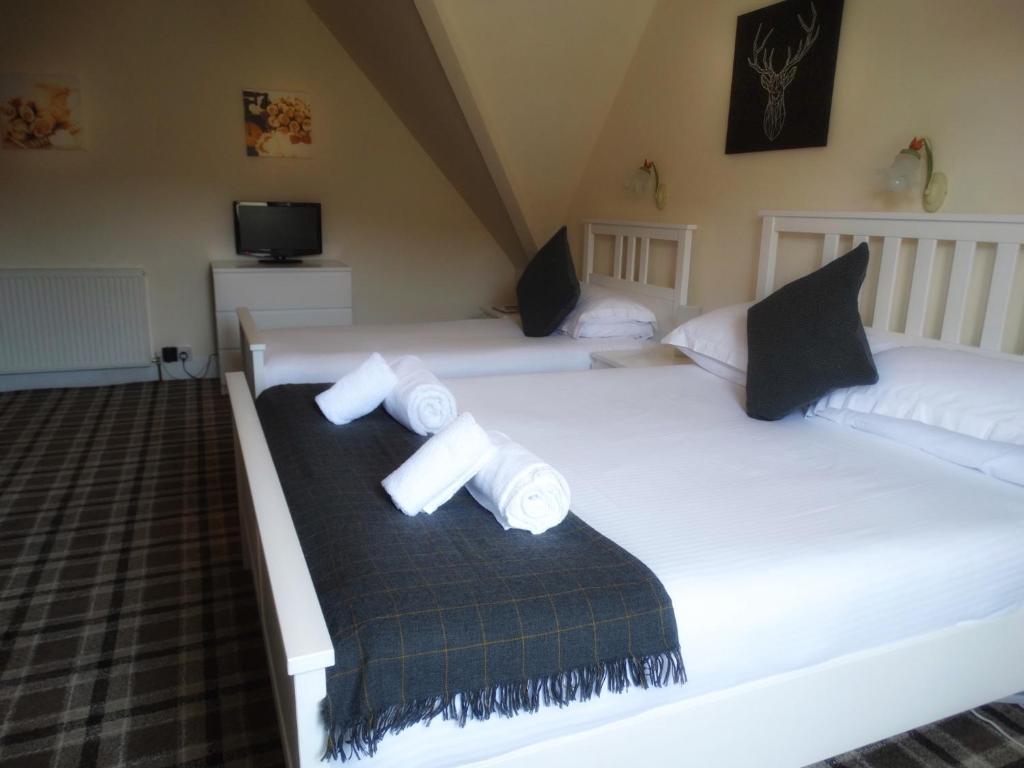 A bed or beds in a room at Kilchoan Hotel