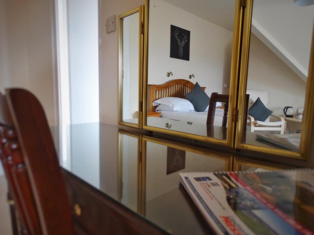 A bed or beds in a room at Kilchoan Hotel