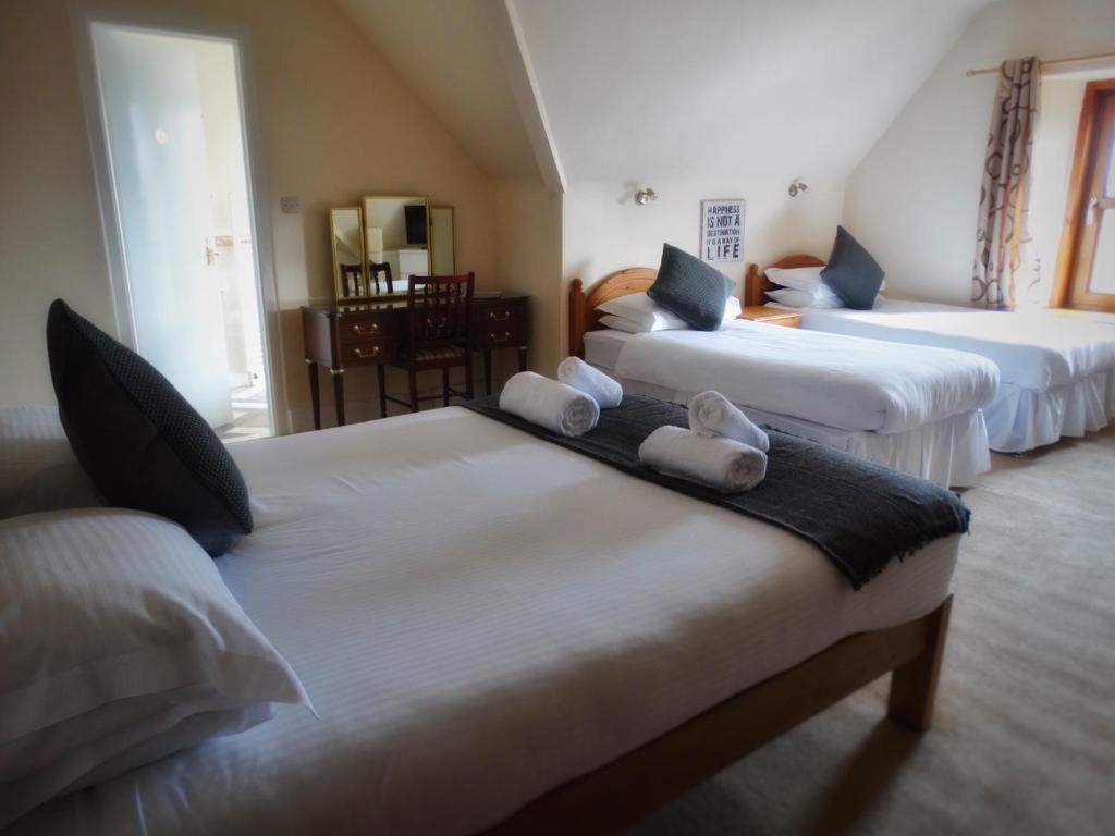 A bed or beds in a room at Kilchoan Hotel