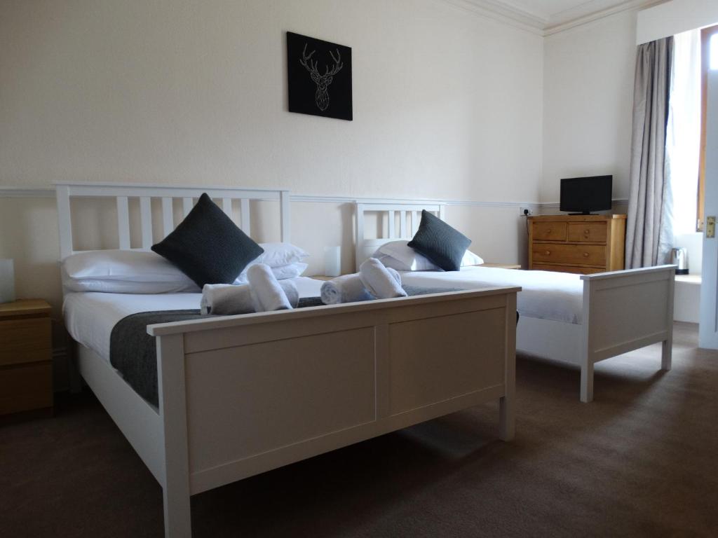A bed or beds in a room at Kilchoan Hotel