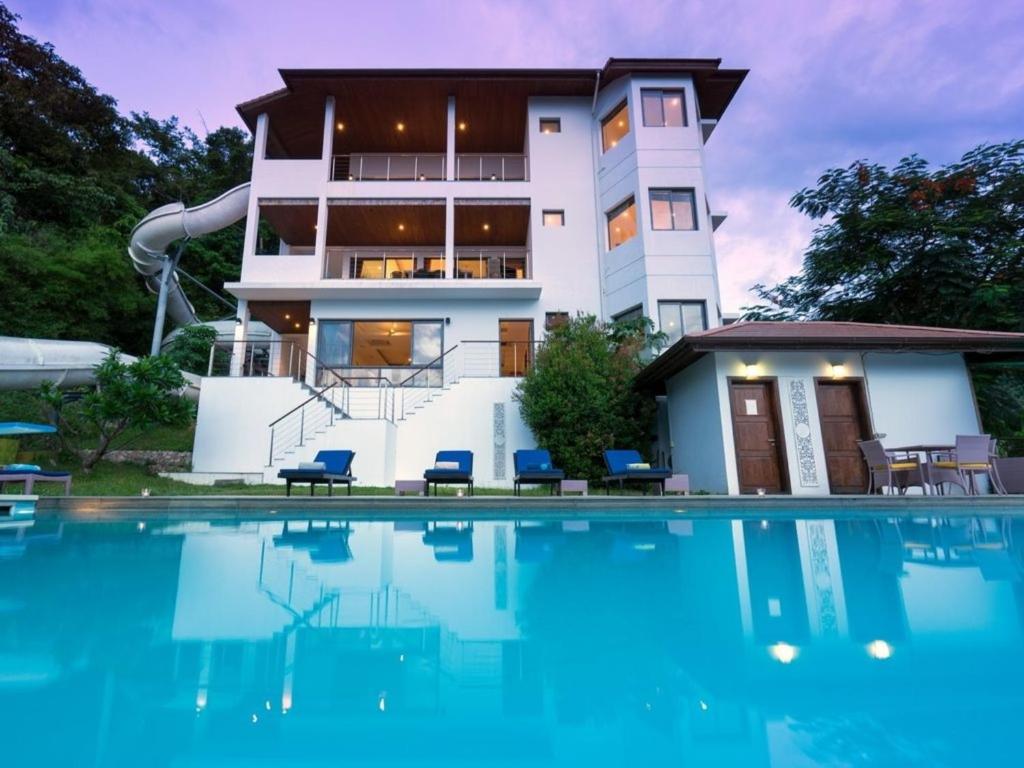 a house with a swimming pool in front of a building at Lulu Villa in Mae Nam