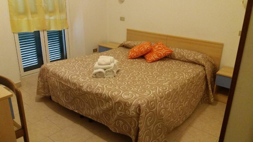 Albergo Ristorante Lavedo في لينّو: غرفة نوم عليها سرير وفوط