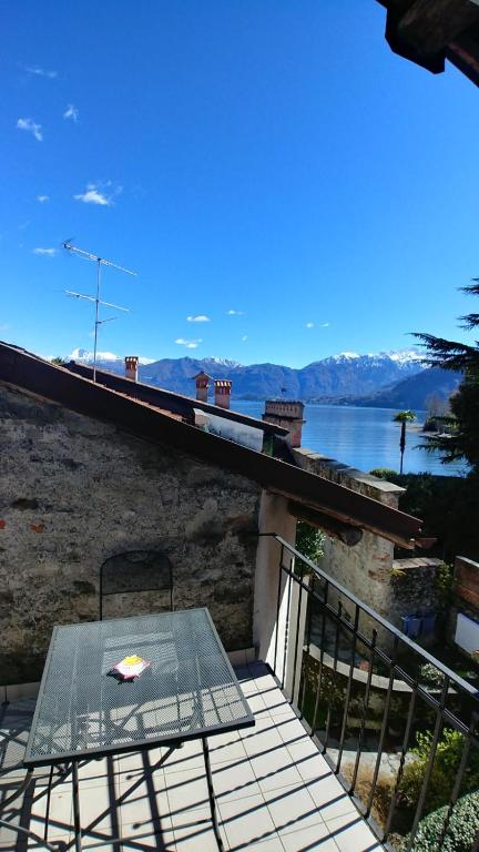 a table on a balcony with a view of the water at Appartamento La Torre in Lenno
