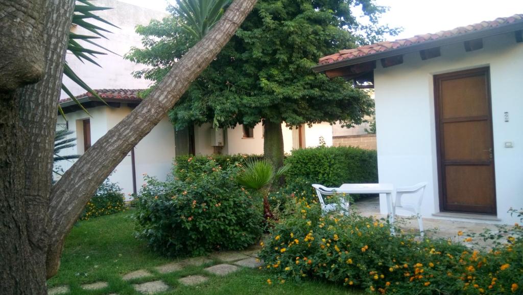 una casa blanca con un banco en el patio en Residence Il Giunco, en Presicce