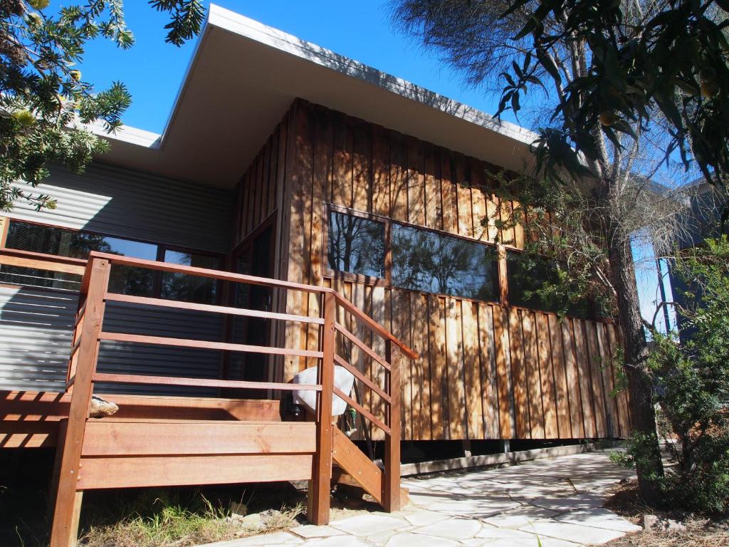 een huis met een houten hek en een houten trap bij Freycinet Studios "Nook" in Coles Bay