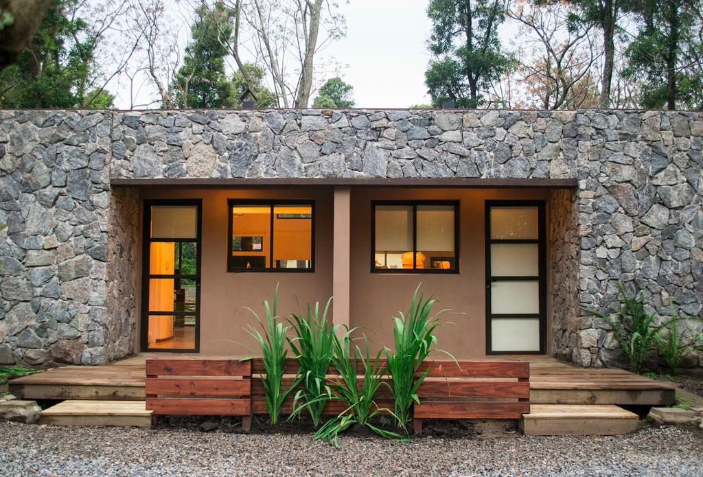 una pequeña casa con una pared de piedra en Cabañas el Ensueño, en Santa Ana