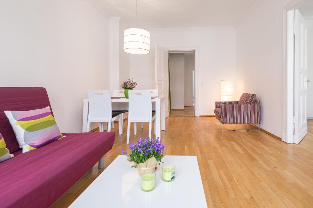 ein Wohnzimmer mit einem lila Sofa und einem Tisch in der Unterkunft Kaiser-Friedrich in Berlin