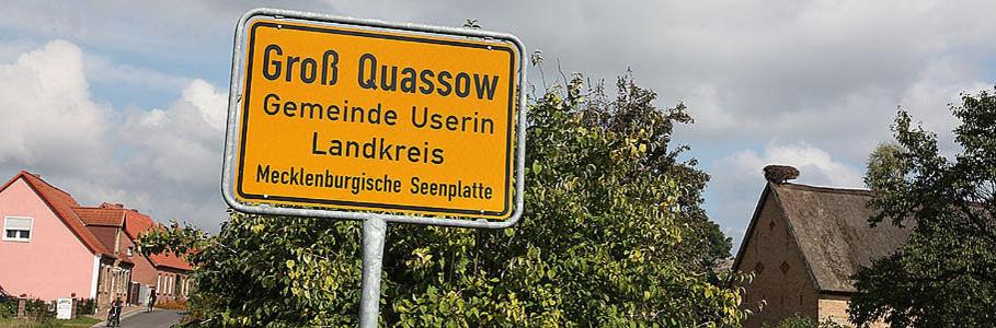 a yellow sign on the side of a street at Pension &amp; Gasthof Storchennest in Groß Quassow