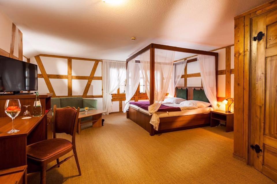 a hotel room with a bed and a desk and a room at Hotel Haus im Sack in Jena