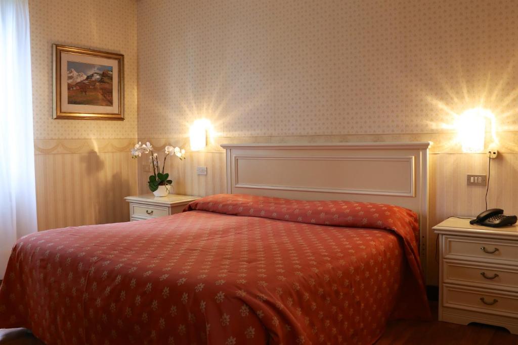 a hotel room with a bed and two night stands at Hotel Du Parc in Stresa