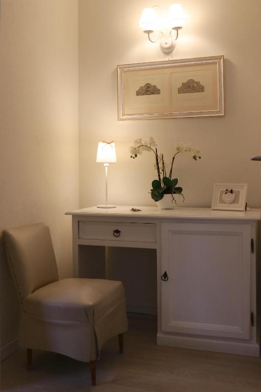 a room with a desk with a lamp and a chair at Hotel Du Parc in Stresa