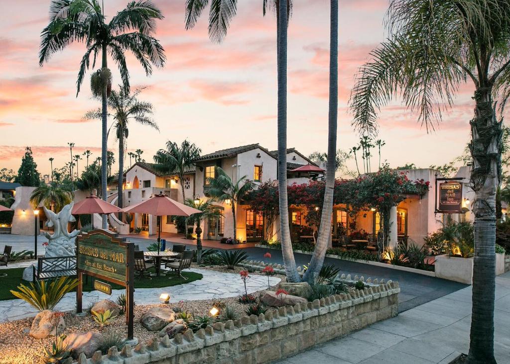 un complejo con palmeras y un cartel en un patio en Brisas Del Mar Inn at the Beach en Santa Bárbara