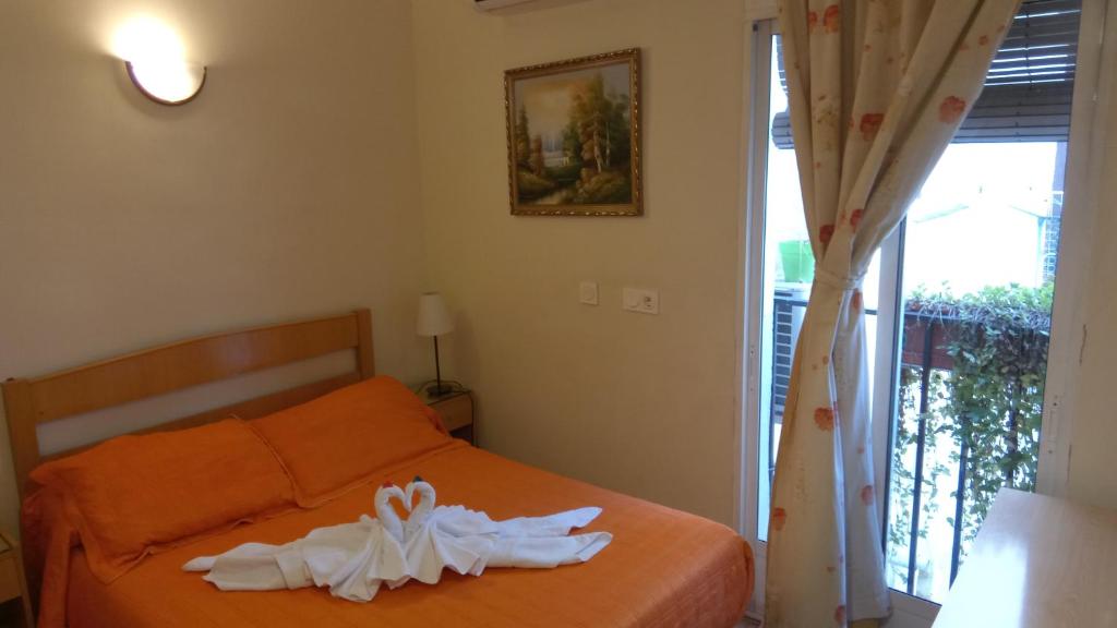 Postel nebo postele na pokoji v ubytování Hostal Huespedes Toledo