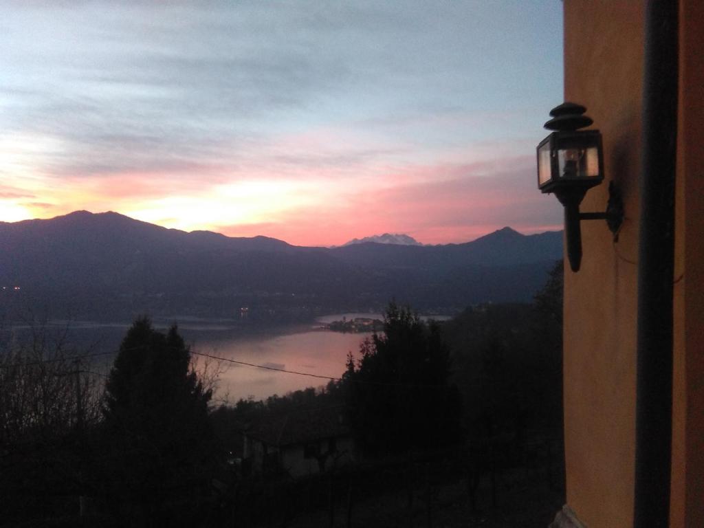een zonsondergang vanuit een raam met uitzicht op een rivier bij Cottage sotto il faggio centenario in Ameno