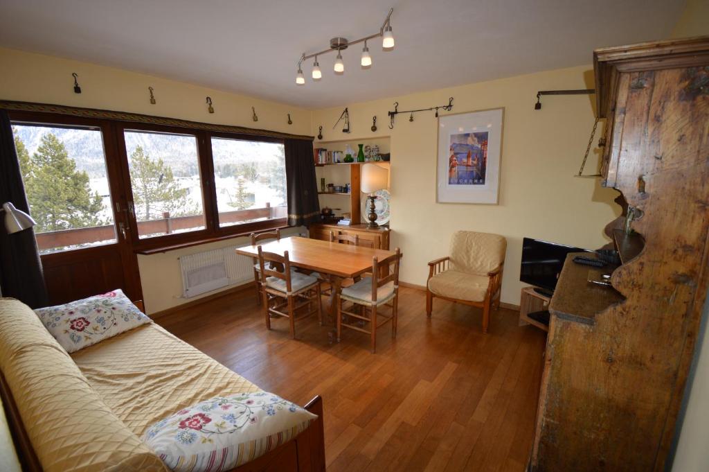 ein Wohnzimmer mit einem Tisch und einem Esszimmer in der Unterkunft Anna House in Celerina
