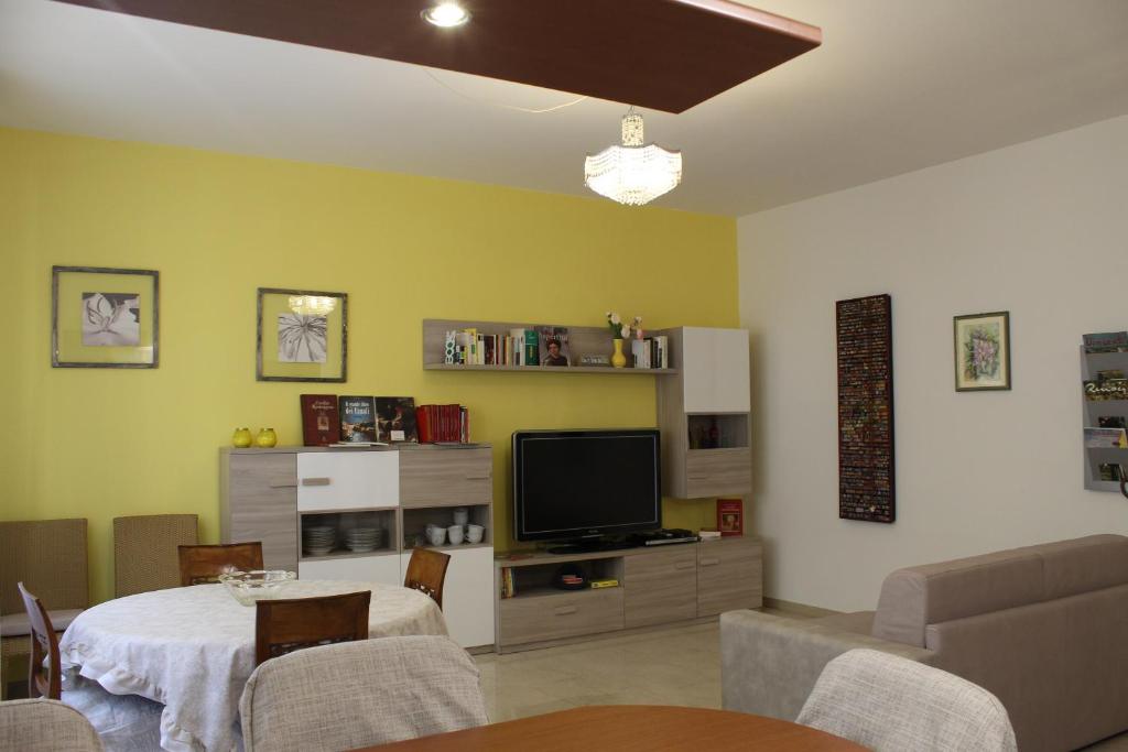 een woonkamer met een tafel en een televisie bij Carbonara Apartment in Bologna