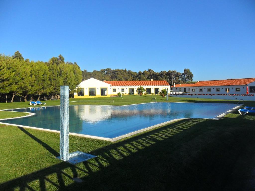 a large swimming pool in front of a building at Monte Carvalhal da Rocha in Zambujeira do Mar