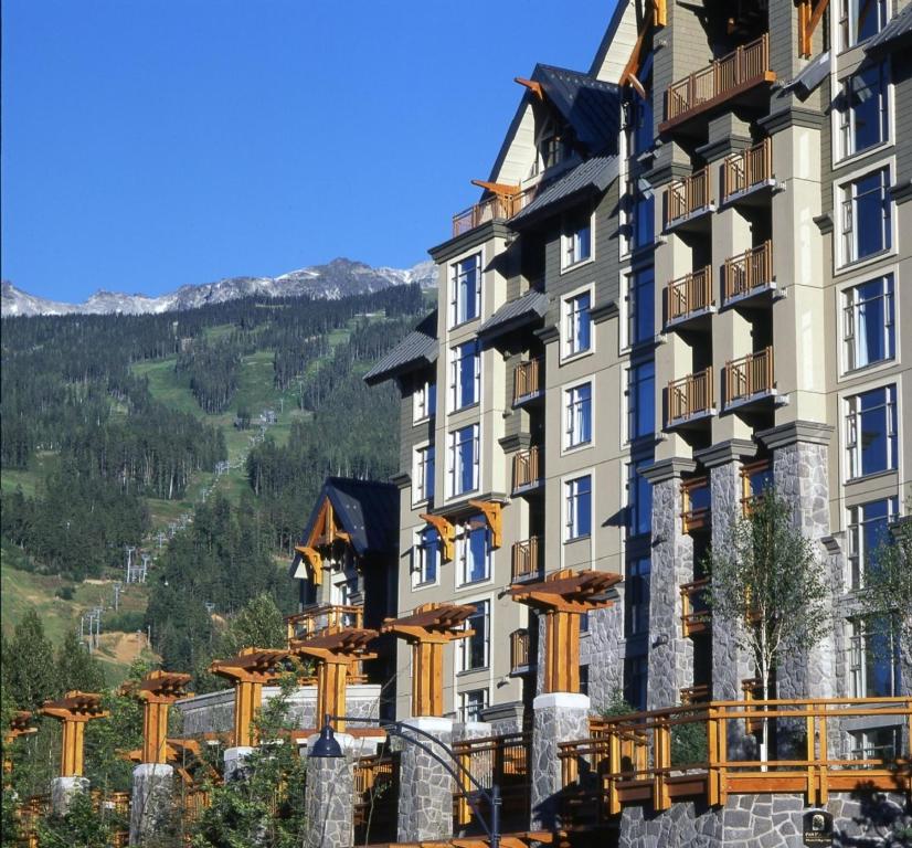 a building with a mountain in the background at Pan Pacific Whistler Village Centre in Whistler