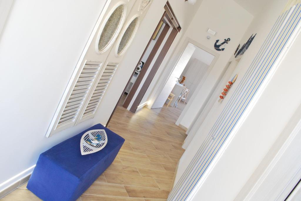 a hallway with a blue ottoman in front of a door at B&B Mare e Templi in Agrigento