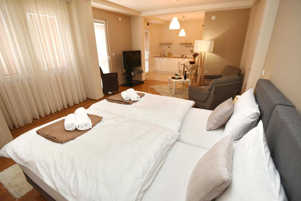 a hotel room with a large white bed and a living room at Villa Mishe in Ohrid
