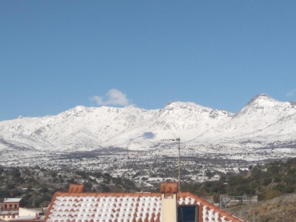 een uitzicht op de met sneeuw bedekte bergen vanuit een gebouw bij El Mirador in Burgohondo