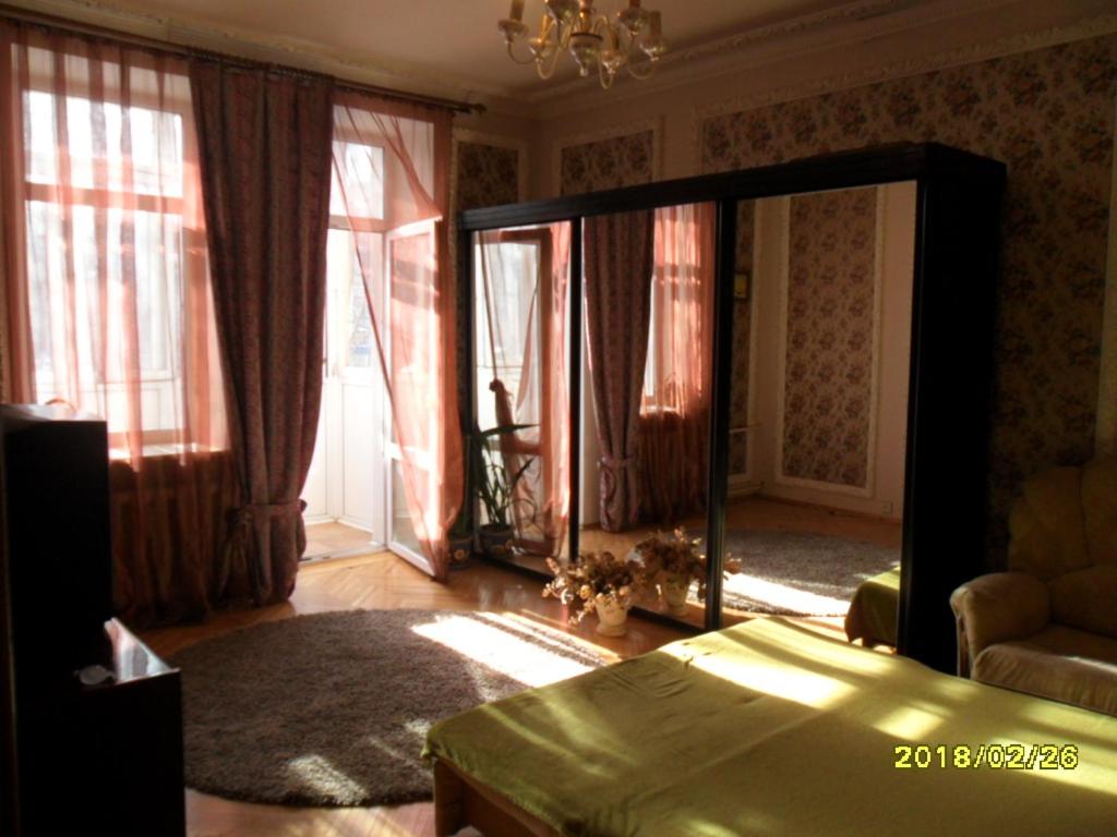 モスクワにあるMoscow Garden View Apartmentのベッドルーム1室(鏡、ベッド1台、窓付)