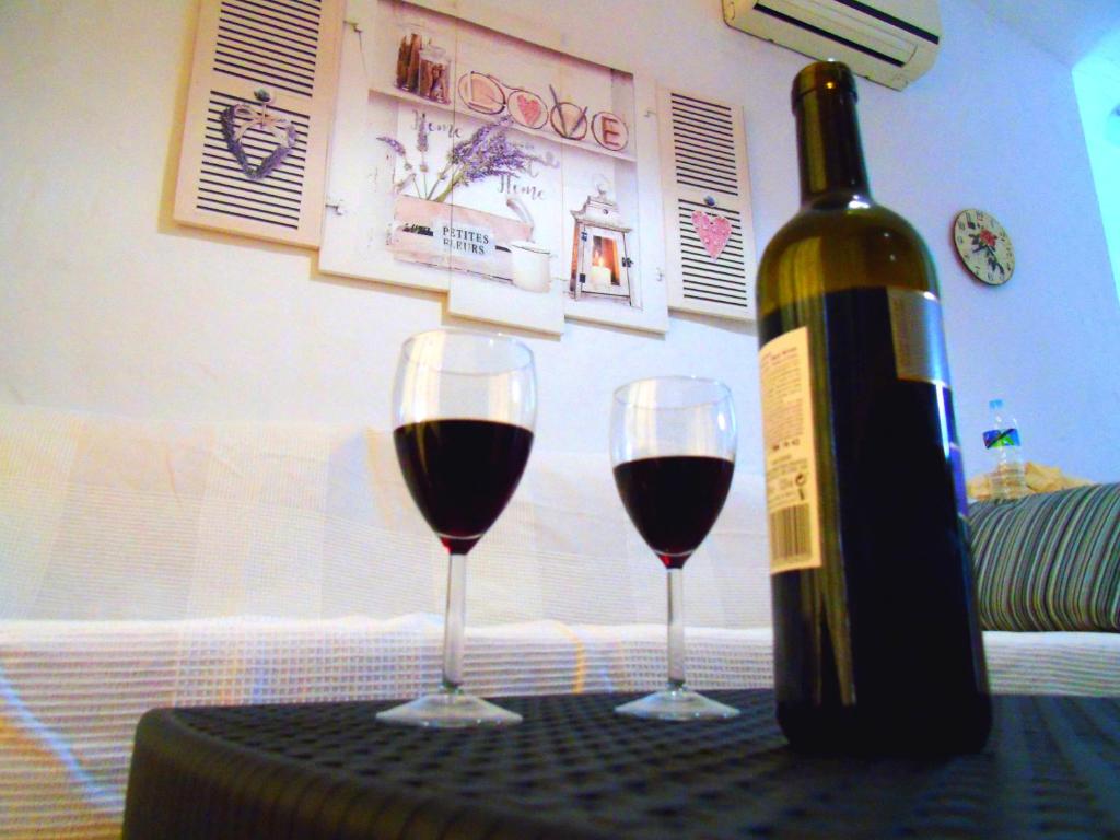マスパロマスにあるbungalow Las TARTANAS I Iのワイン1本とテーブル上のワイン2杯