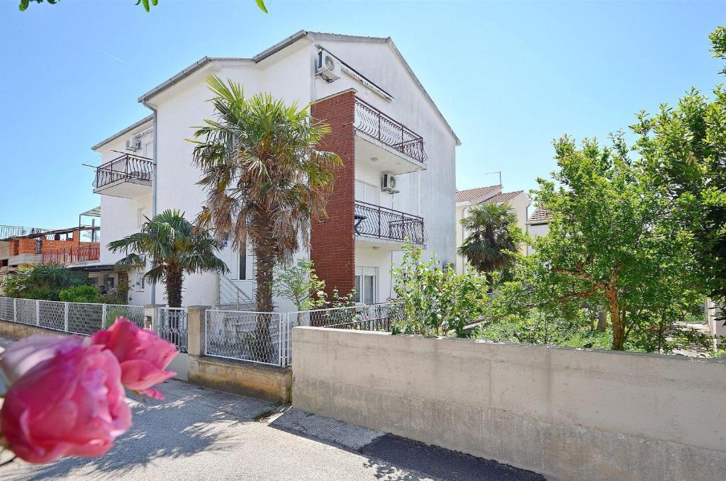 eine rosa Blume vor einem weißen Gebäude in der Unterkunft Apartments and Rooms Josipa in Vodice