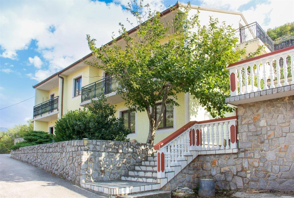 a house with stairs in front of a building at Apartments Marijana in Senj