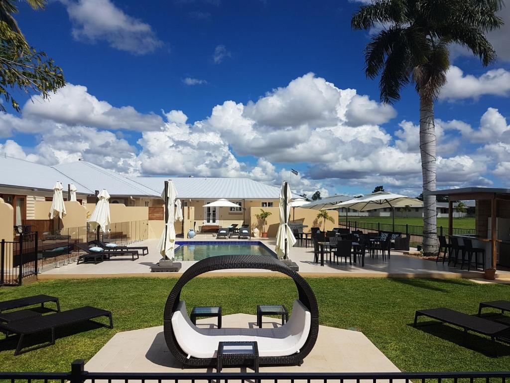 Blick auf ein Resort mit einem Pool und einer Bank in der Unterkunft Kernow - Minimum age 18 in Charters Towers
