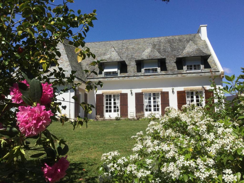 una casa grande con flores delante en Villa Lucie, en Ploemeur