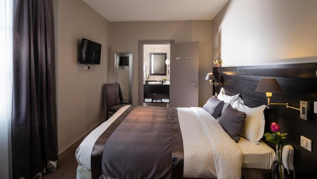 a hotel room with a large bed and a bathroom at La Place Boutique Hotel in Antibes