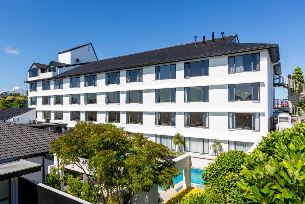 an image of a white building with a swimming pool at Plymouth International in New Plymouth