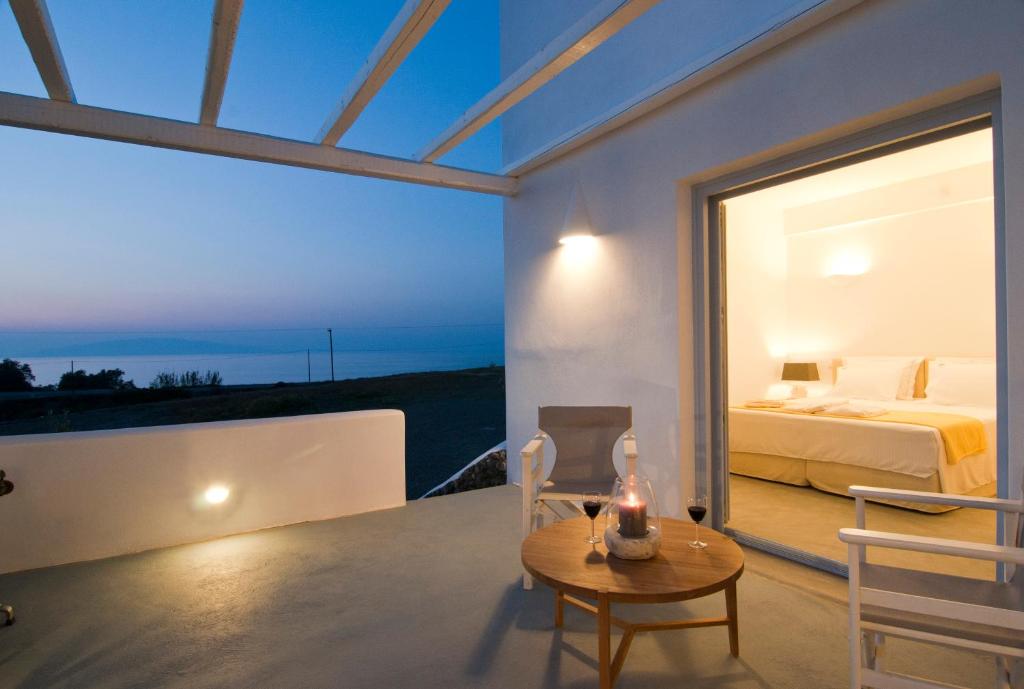a bedroom with a bed and a table with a candle at Sun Anemos Resort in Oia