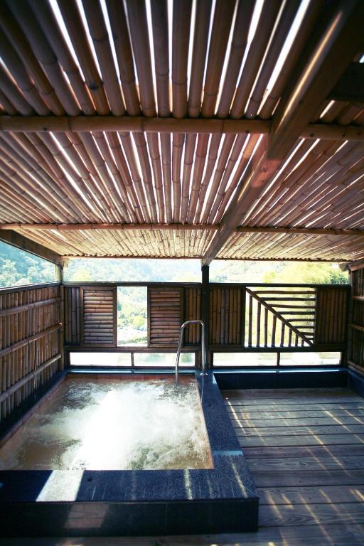 a hot tub in a covered deck with a wooden ceiling at King&#39;s Resort &amp; Spa in Tai&#39;an