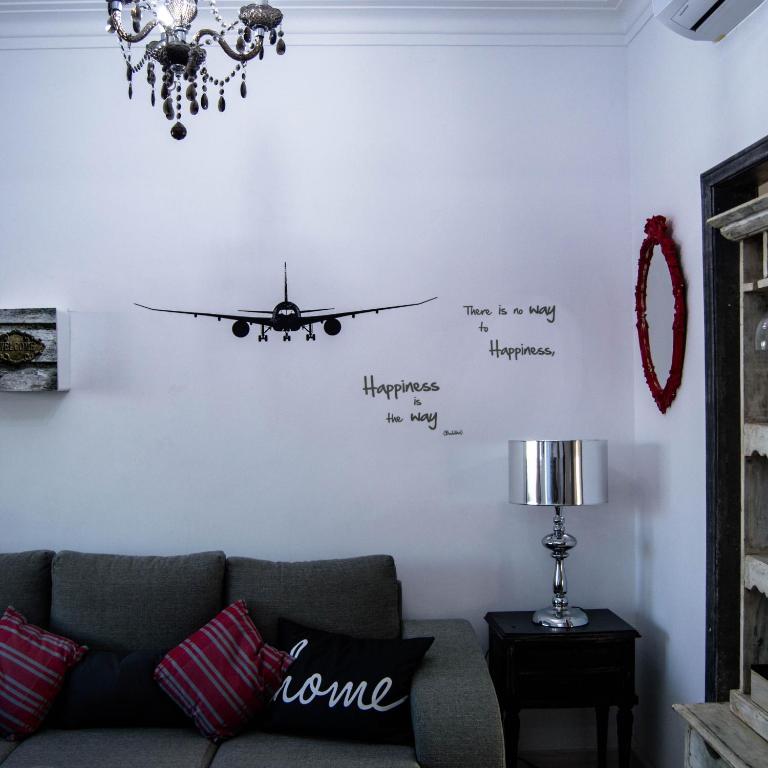 a living room with a couch and a clock on the wall at Lisbon Hostel Terminal 3 in Lisbon