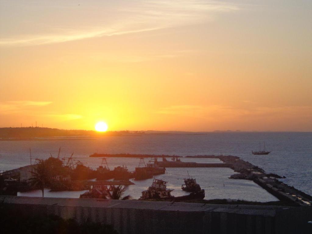 una puesta de sol sobre un cuerpo de agua con la puesta de sol en STUDIO EM FORTALEZA NO CONDOMINIO VILA DE IRACEMA, en Fortaleza