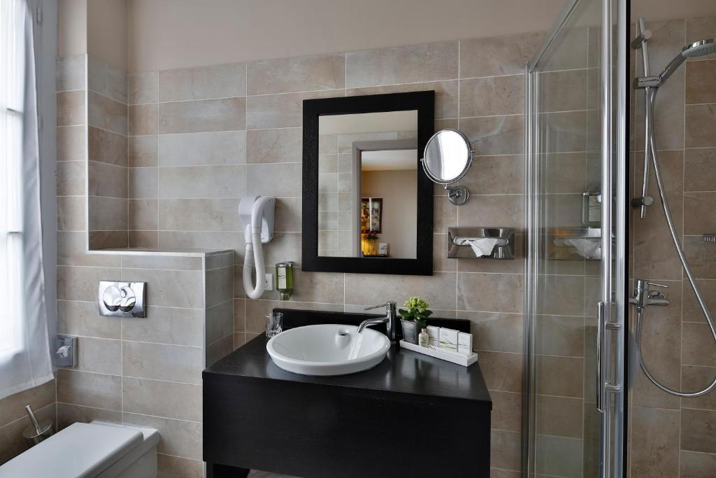 a bathroom with a sink and a shower at La Place Boutique Hotel in Antibes