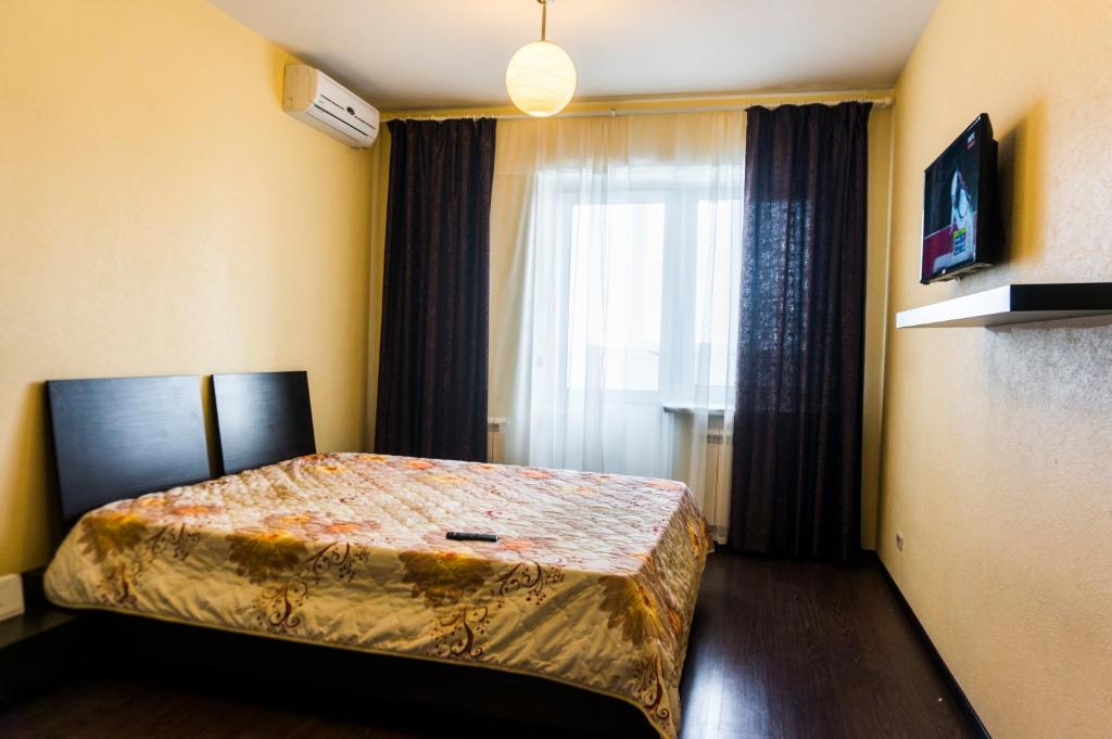 キーロフにあるЧапаева 49бのベッドルーム1室(ベッド1台付)、窓(カーテン付)