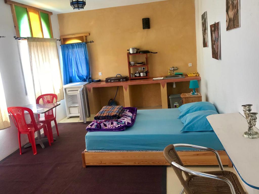 a bedroom with a bed and a table and chairs at Gite Le Nomade in Mirleft