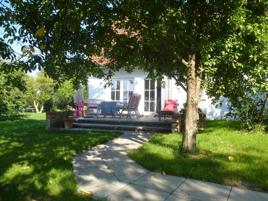 a house with a table and chairs in a yard at Witzuk, ruhiges Strandhaus in Warnkenhagen