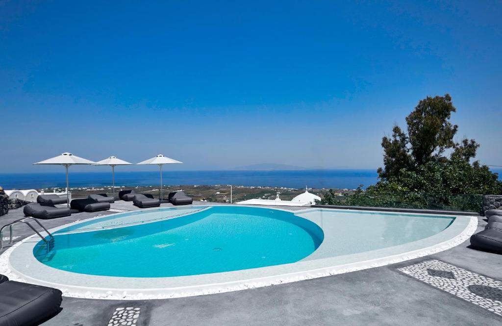 a swimming pool with a blue ocean view at Anchor Suites in Oia