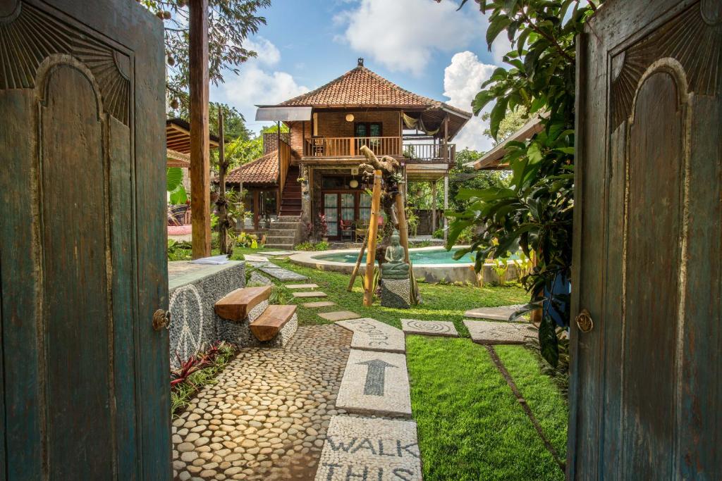 an open door to a house with a swing at Woodstock In The Village in Singaraja