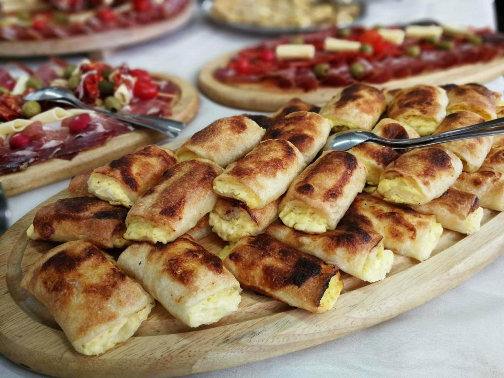 une assiette de nourriture sur une table avec des pizzas dans l'établissement Pansion Rody, à Gornja Stubica