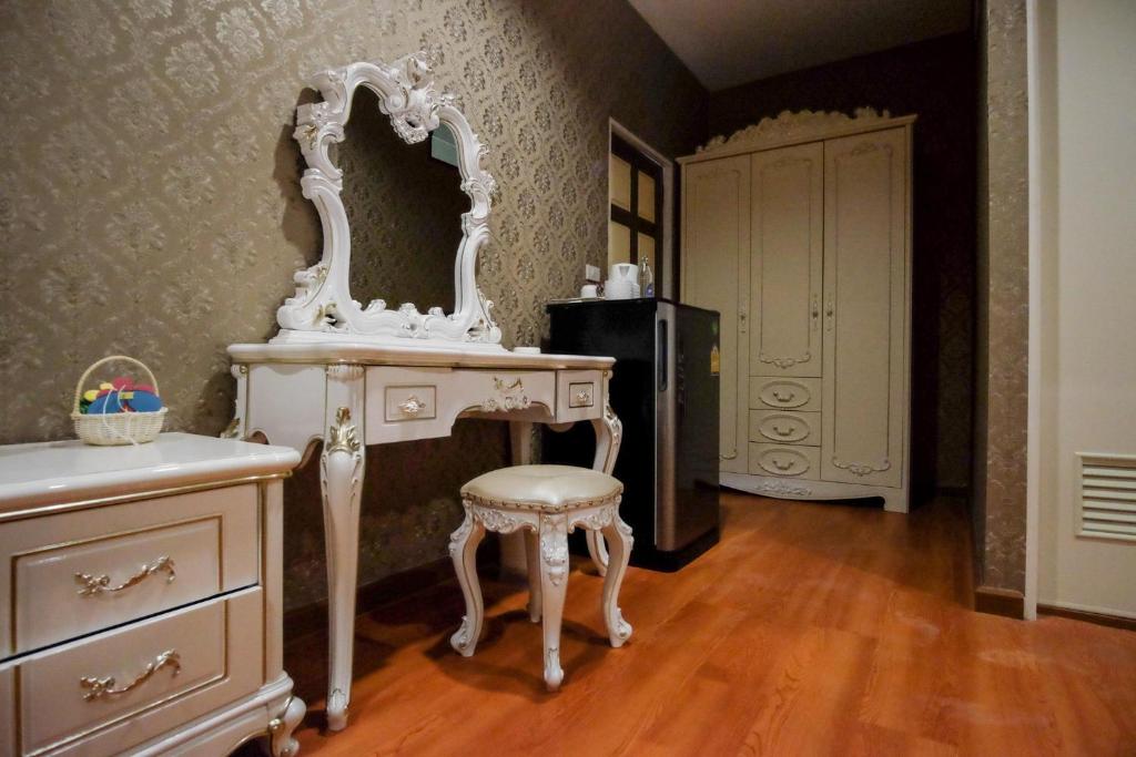 a white dressing table with a stool and a mirror at The O-Zone Airport Inn in Ban Khlong Prawet
