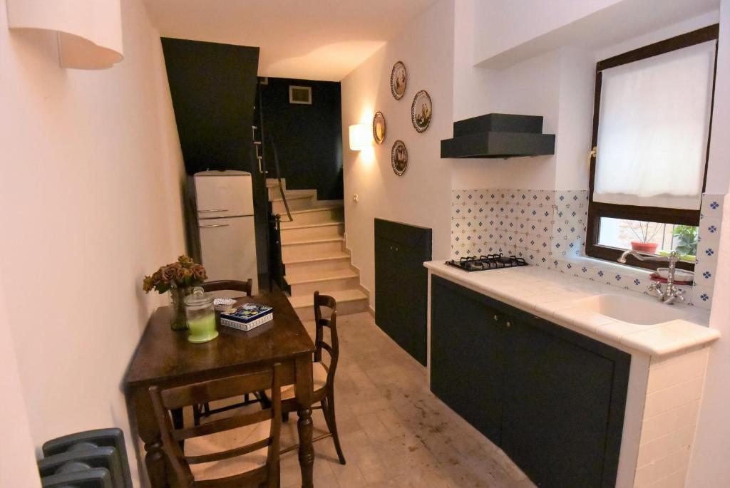 a kitchen with a small table and a kitchen with a stairway at La casetta a Torre di Palme in Fermo