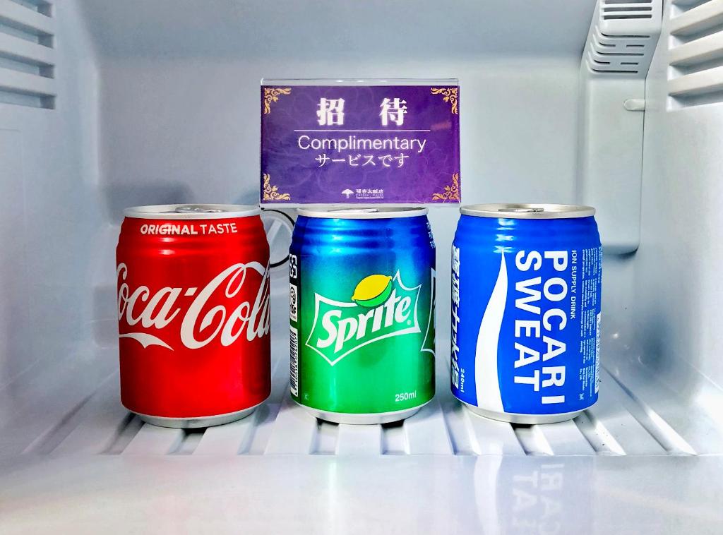 three cans of soda are sitting in a refrigerator at Fullon Hotel Taoyuan Airport Access MRT A8 in Guishan